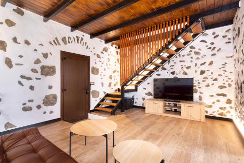 a living room with a couch and a tv at Home2Book Rustic Stone Haven with Terrace in La Guancha