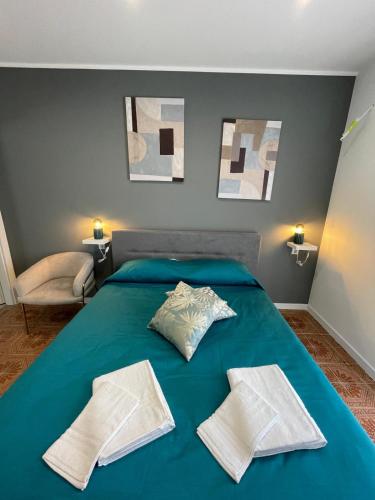 a bedroom with a blue bed with two pillows on it at Vento di Sicilia in Carini