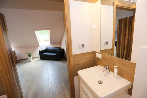 a bathroom with a sink and a mirror and a chair at Abies Villa in Zagnańsk