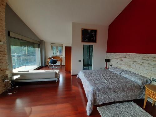 a bedroom with red walls and a bed and a tub at Villa con piscina privada, 2 jacuzzis y barbacoa in Benicàssim