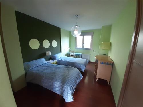 two beds in a room with green walls at Villa con piscina privada, 2 jacuzzis y barbacoa in Benicàssim