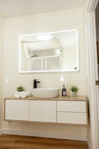 a white bathroom with a sink and a mirror at Precioso apartamento en Cazorla con vista a la montaña, naturaleza, WI FI gratuito in Cazorla