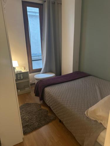 une petite chambre avec un lit et une fenêtre dans l'établissement Bel Appartement Paris 11, à Paris