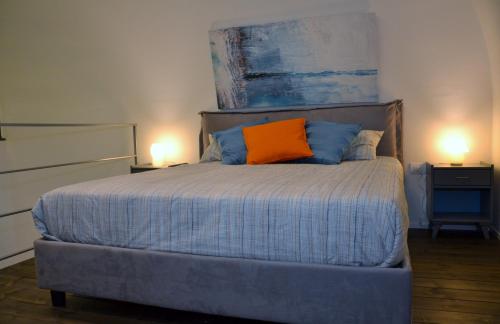 a bedroom with a bed with an orange pillow on it at Exclusive Suite San Biagio 25 in Naples