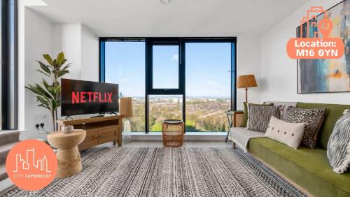 a living room with a green couch and large windows at Rooftop Flat Stunning City View by City SuperHost in Manchester