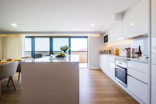 a kitchen with white cabinets and a kitchen island at The Shoreline 4 by Portugal Portfolio in Parede