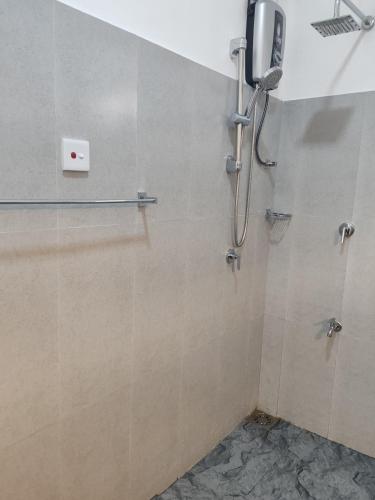 a bathroom with a shower with a phone on the wall at Mahaweli View Inn in Kandy