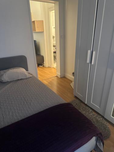 une chambre avec un lit et une porte donnant sur un couloir dans l'établissement Bel Appartement Paris 11, à Paris