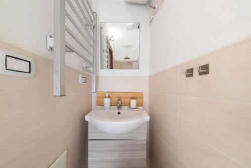 a bathroom with a sink and a mirror at SASSARI-CENTRO Elegante Appartamento con WiFi e Netflix in Sassari