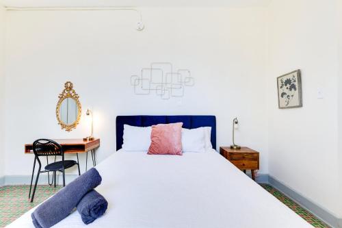 Chic & Cozy Stay in Trendy Miramar في سان خوان: غرفة نوم بسرير مع مكتب وكرسي