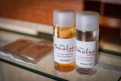 two bottles of moisturizers sitting on a glass table at Omalia Village in Áno Khóra
