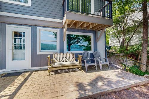 two chairs and a bench on a patio in front of a house at QKA View in Penn Yan