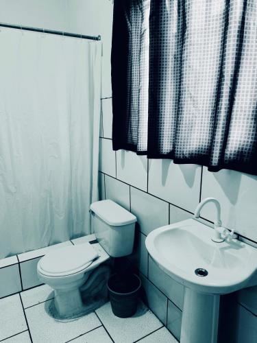 a white bathroom with a toilet and a sink at Miami Studios DR in Santo Domingo