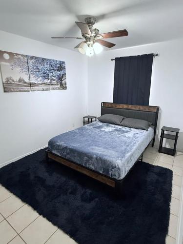 Un dormitorio con una cama y un ventilador de techo. en Work or Relax Convention center, en McAllen