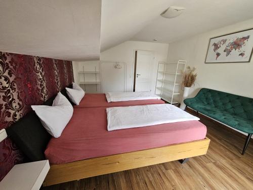 a bedroom with two beds and a green couch at RoSa Seeblick in Steingädele