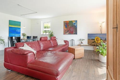 een woonkamer met een rode leren bank bij Achtern Hoff in Gnissau