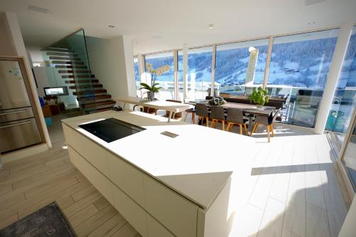 a large kitchen and living room with a table and chairs at Villa Wie I in Kaprun