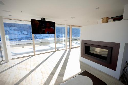 a living room with a fireplace and a flat screen tv at Villa Wie I in Kaprun