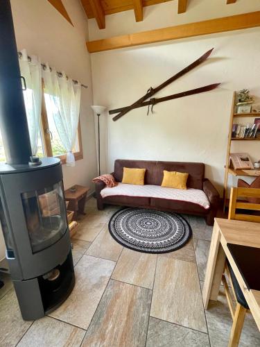 a living room with a couch and a clock on the wall at Charmante maisonnette avec vue sur les montagnes in Chalais