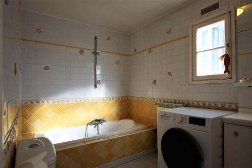une salle de bain avec baignoire et machine à laver dans l'établissement Sur les hauteurs de Nice, belle villa idéale en famille ou entre amis, à Colomars