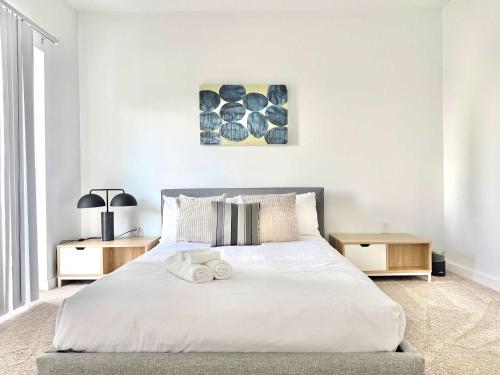 a bedroom with a white bed with two night stands at 2B2B Condo in ATL Penthouse level 542Blvd402 in Atlanta