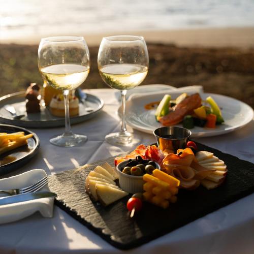 a table with glasses of wine and a plate of food at CC Beach Front Papagayo All Inclusive in Papagayo, Guanacaste