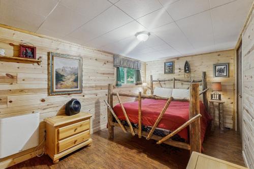 a bedroom with a bed in a room with wooden walls at The Creekside Cabin in Cascade