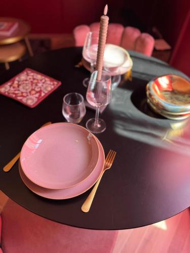 a table with a pink plate and glasses on it at RED SPARROW -T2 avec jacuzzi in Châteauroux