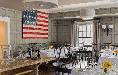 uma sala de jantar com uma bandeira americana na parede em The Inn at Hastings Park, Relais & Châteaux em Lexington