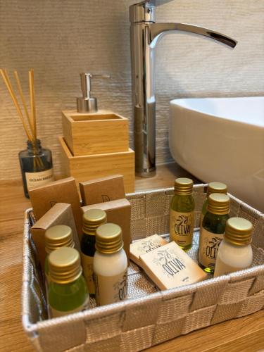 een mand met flesjes etherische oliën naast een gootsteen bij Fanzago Home in Pisogne