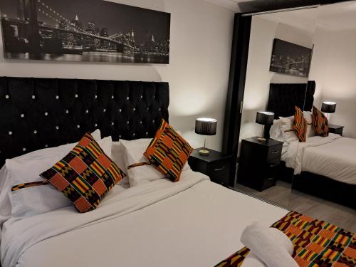 a bedroom with two beds and a large mirror at FANTASTIC COZY 3bed Hse London ExCEL Free Parking WIFI Sleeps 6 in London