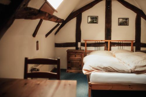 Un dormitorio con una cama y una mesa de madera. en Historisches Haus im Herzen von Monschau, en Monschau
