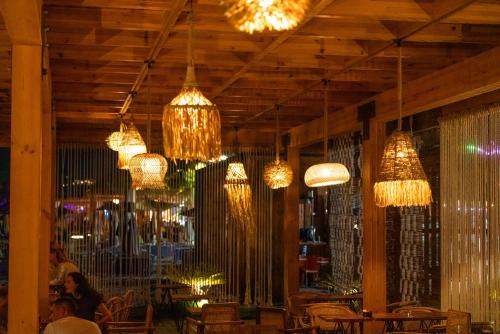 a restaurant with chandeliers hanging from the ceiling at Vila Lasko Hotel in Golem
