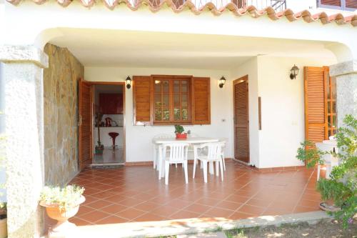 a patio with a white table and chairs at Casa Su Lizzu in Tanaunella