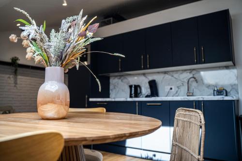 un vase de fleurs assis sur une table dans une cuisine dans l'établissement Entre Parenthèse, à Warlus