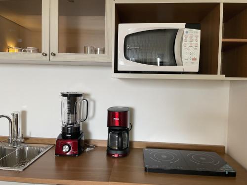 a kitchen counter with a blender and a microwave at Apart-Hotel Vila Mariana in Sao Paulo