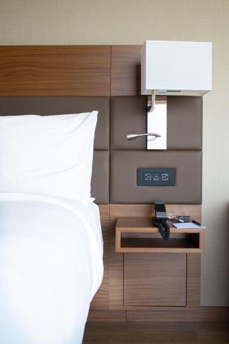 a bedroom with a bed and an alarm clock at AC Hotel By Marriott Salt Lake City Downtown in Salt Lake City