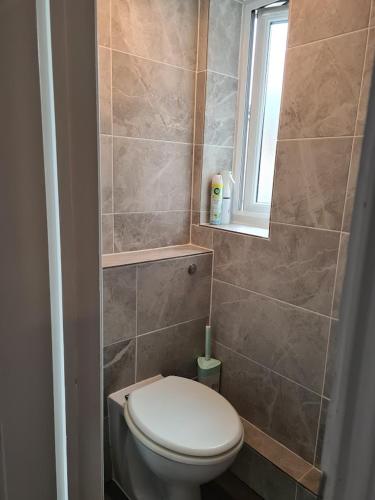 a small bathroom with a toilet and a window at FANTASTIC COZY 3bed Hse London ExCEL Free Parking WIFI Sleeps 6 in London