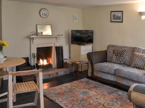 ein Wohnzimmer mit Couch und Kamin in der Unterkunft Blackberry Cottage in Kenton