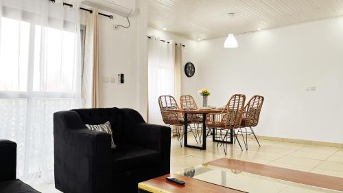 a living room with a table and chairs at Residence Atlantic - Premium Apartment - WiFi, Gardien, Parking, Climaté in Douala