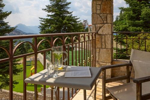 a table with glasses and a book on a balcony at Omalia Village in Áno Khóra
