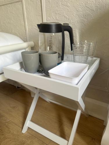 a white shelf with cups and a coffee pot on it at Modern Twin Room In The Heart Of Edinburgh in Edinburgh