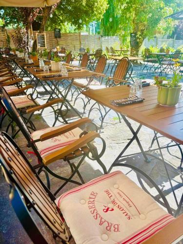 a row of wooden tables and chairs with towels at Hôtel Restaurant "La Petite Auberge" in Bourg-Saint-Maurice