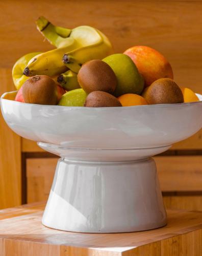 a white bowl of fruit on a table at Elysée Montmartre Hotel in Paris