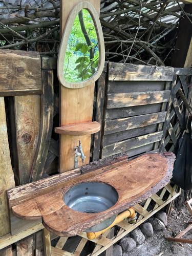 a wooden outhouse with a wooden sink and a mirror at Waldfloß Biberspur in Zieko