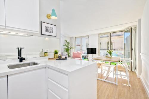 a kitchen with white cabinets and a dining room at Solaga - Ático Sebastián Souvirón in Málaga