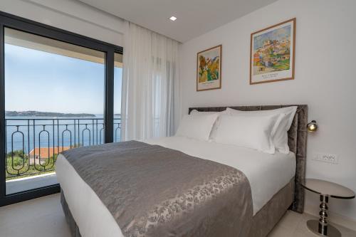 une chambre avec un lit et une grande fenêtre dans l'établissement Villa Mariva, à Mlini