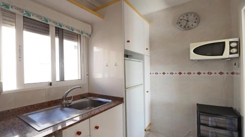 a kitchen with a sink and a clock on the wall at R-2428 APARTAMENTO CORINTO in La Mata