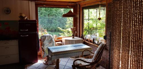 a kitchen with a table and chairs and a window at Urgemütliches Bungalow am See in Schwielochsee