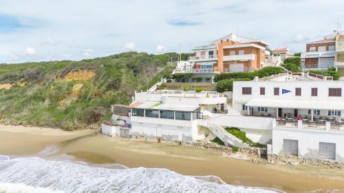 a group of buildings on a beach next to the water at Sea View Suite with Parking and Private Garden in Anzio